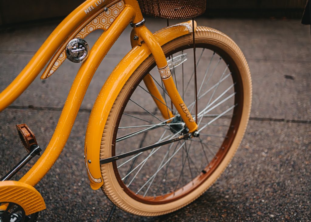 a close up of a yellow bicycle with a basket